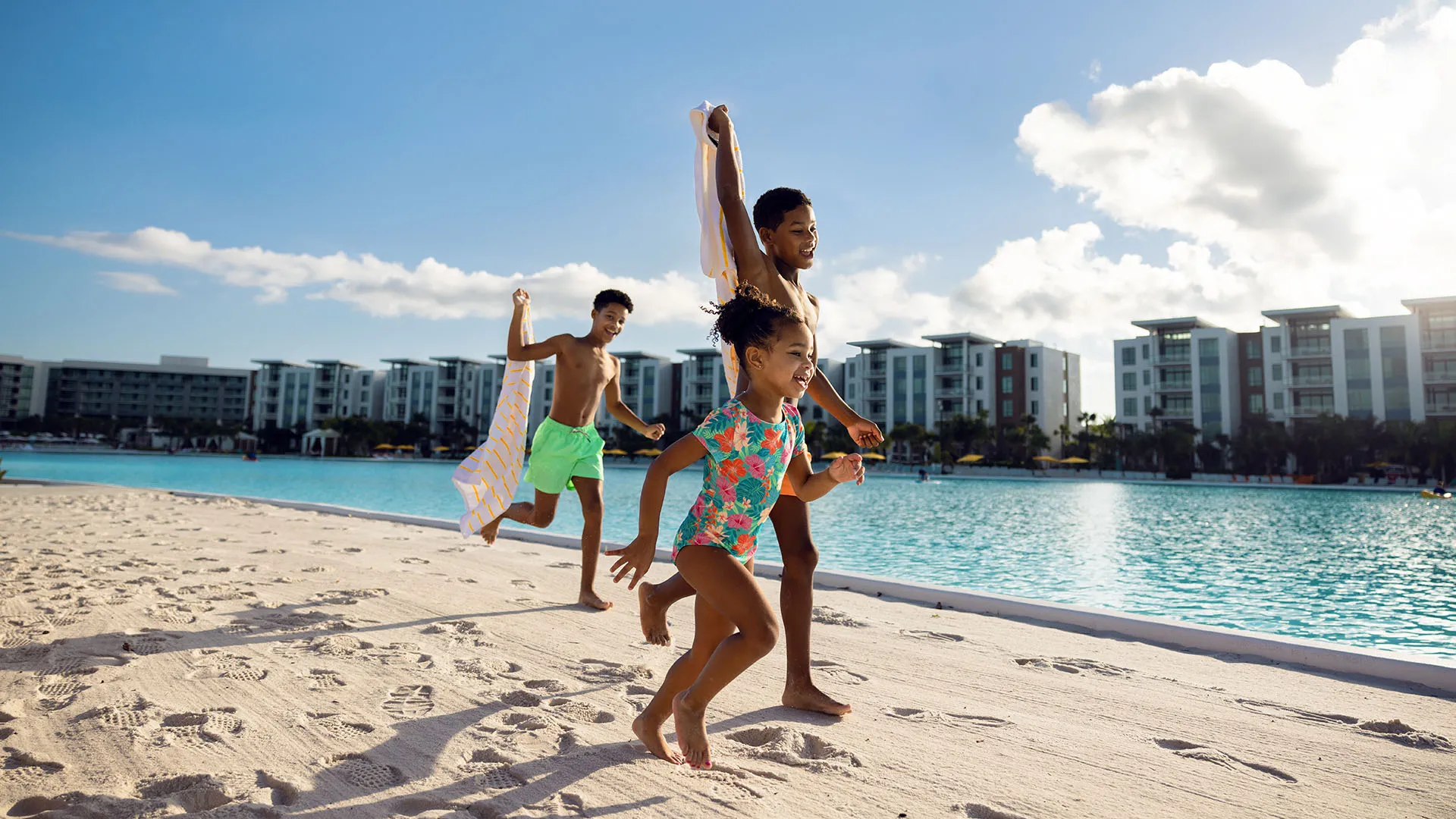 Kids Playing on the Beach by Evermore Bay An image of three kids smiling while playing on the beach by Evermore Bay at Evermore Orlando Resort.