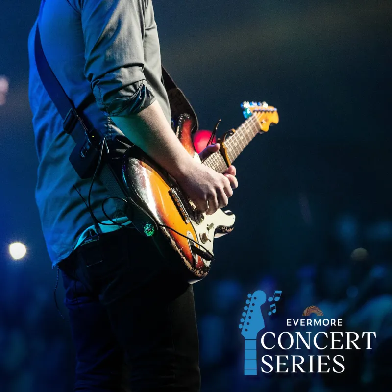 Guitar Player at Concert - Evermore Concert Series An image of a man playing an electric guitar at an outdoor concert with the Evermore Concert Series logo overlaid.