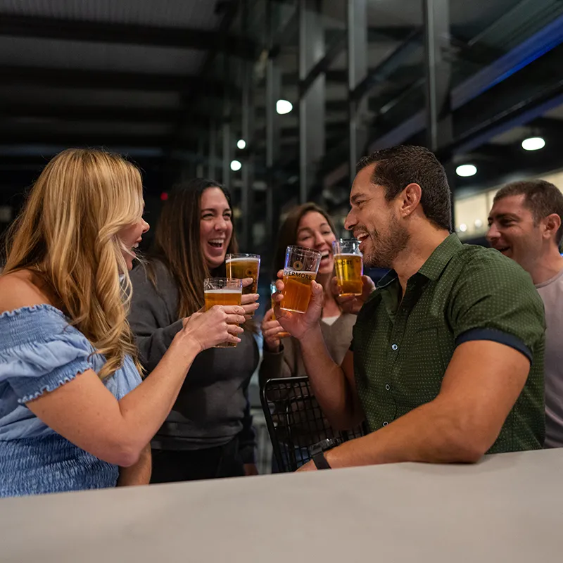 Drinks at ebb + flow Bar An image of guests enjoying beers at ebb + flow Bar in The Landing at Evermore Orlando Resort.