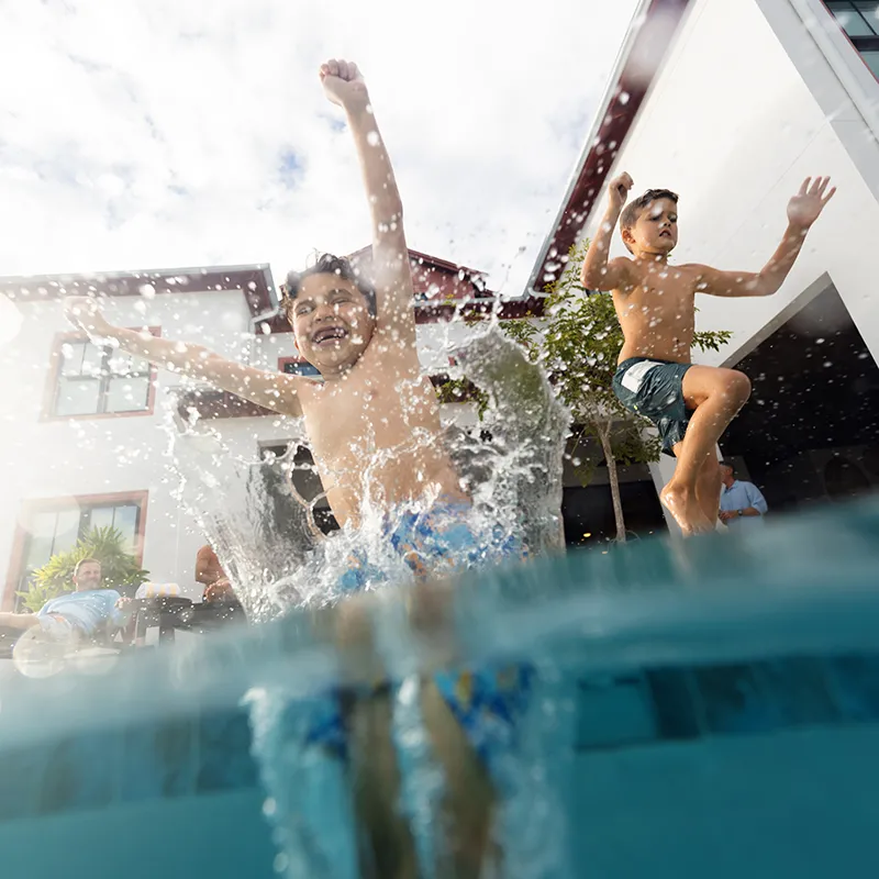 Kids Splashing into Private Heated Pool An image of two kids splashing into a private heated pool at a vacation rental house at Evermore Orlando Resort.