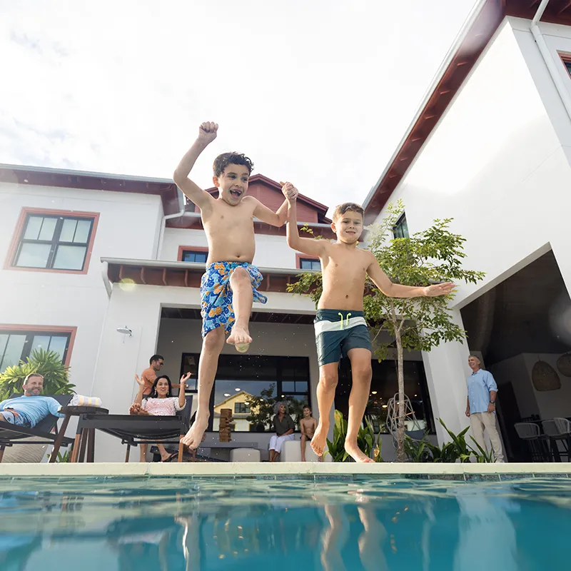 Kids Jumping into Private Heated Pool An image of two kids jumping into a private heated pool at a vacation rental house at Evermore Orlando Resort.