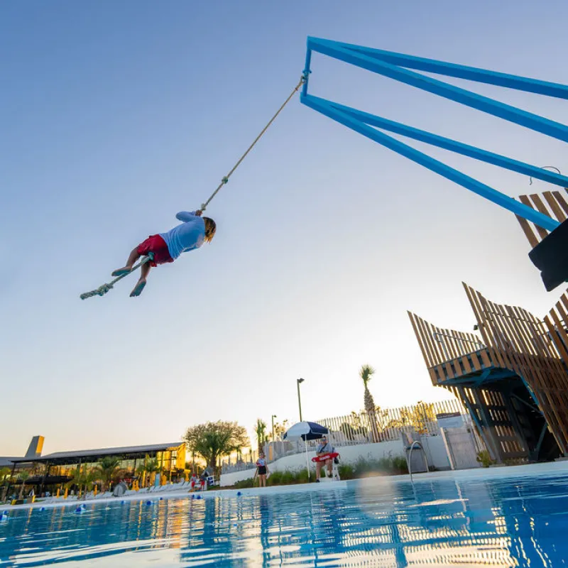 Kid swinging on rope over Blue hole Kid swinging on rope over Blue hole