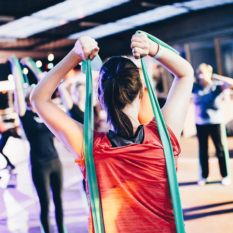 Guests Exercising in a Fitness Class An image of a woman exercising with resistance bands in a fitness class