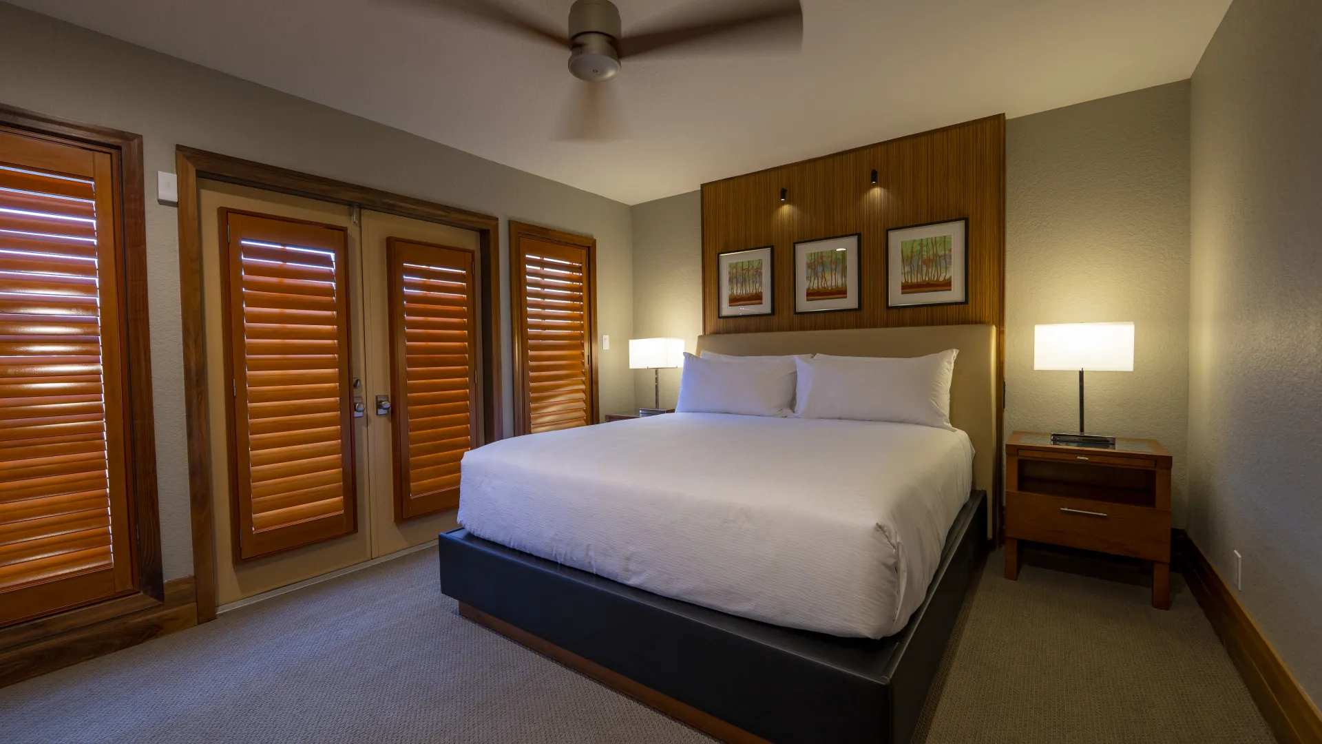 Villa king bedroom An image of an Evermore Orlando Resort Villa bedroom featuring a plush king-sized bed and a set of doors that lead out to an exterior patio..