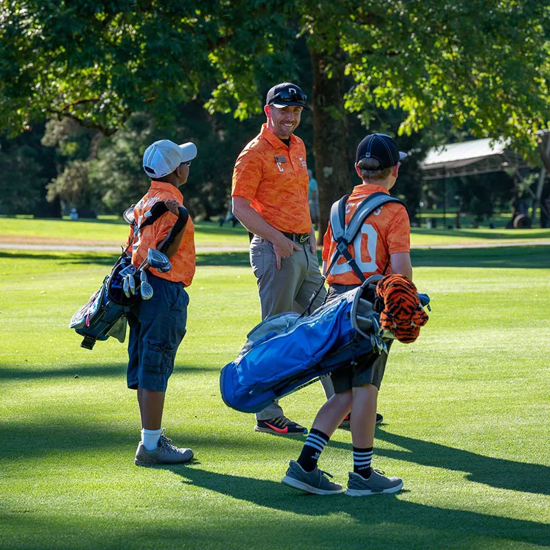 Grand Cypress Golf Summer Camp PGA Instructor An image of a PGA instructor teaching children about on course play during a Grand Cypress Golf summer camp at Evermore Orlando Resort.