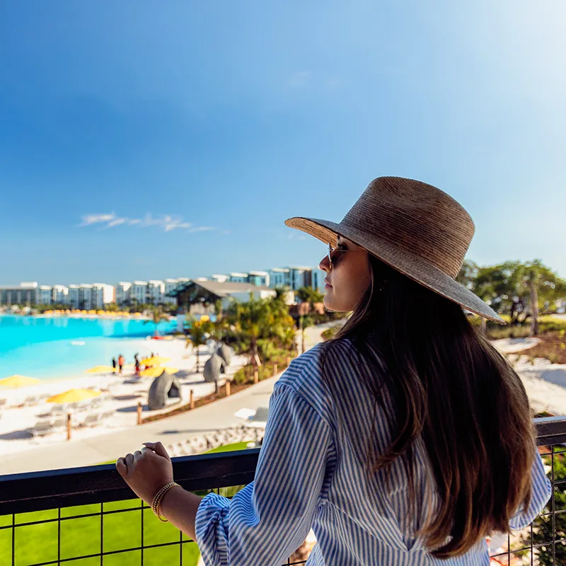Wellness at Evermore Bay An image of a woman relaxing and recharging while on vacation and overlooking Evermore Bay at Evermore Orlando Resort.