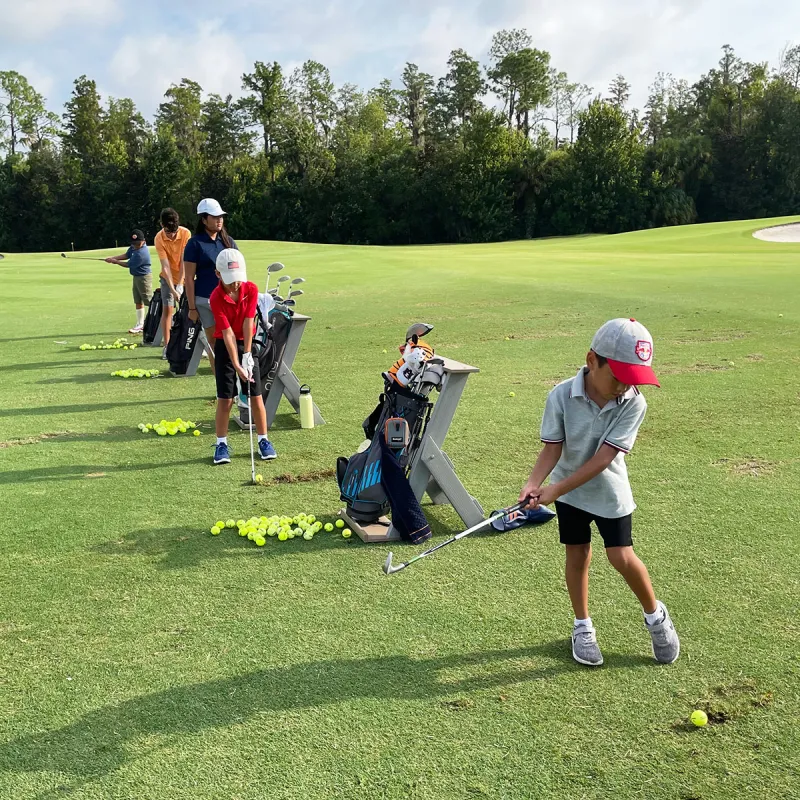 Grand Cypress Golf Junior Camp An image of children practicing chipping during a Grand Cypress Golf junior camp at Evermore Orlando Resort.