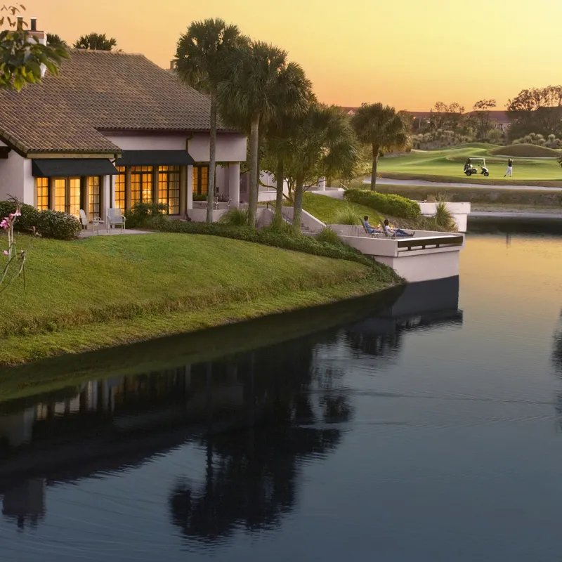 Evermore Villas Exterior Shot of Guests Enjoying Sunset on Patio overlooking Golf Course